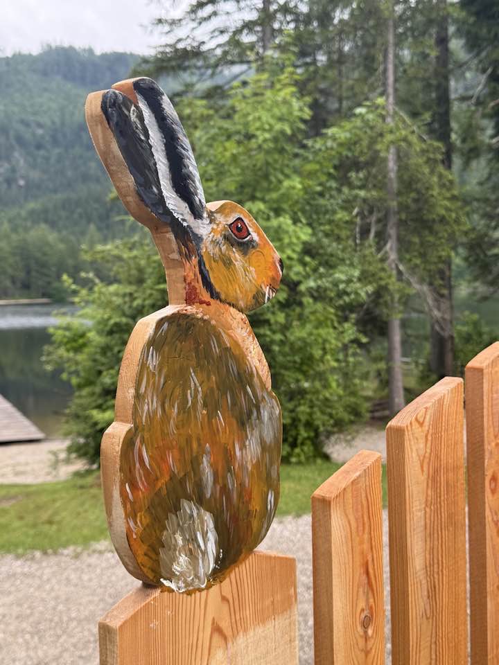 Holzhase am Zaun des Spielplatzes