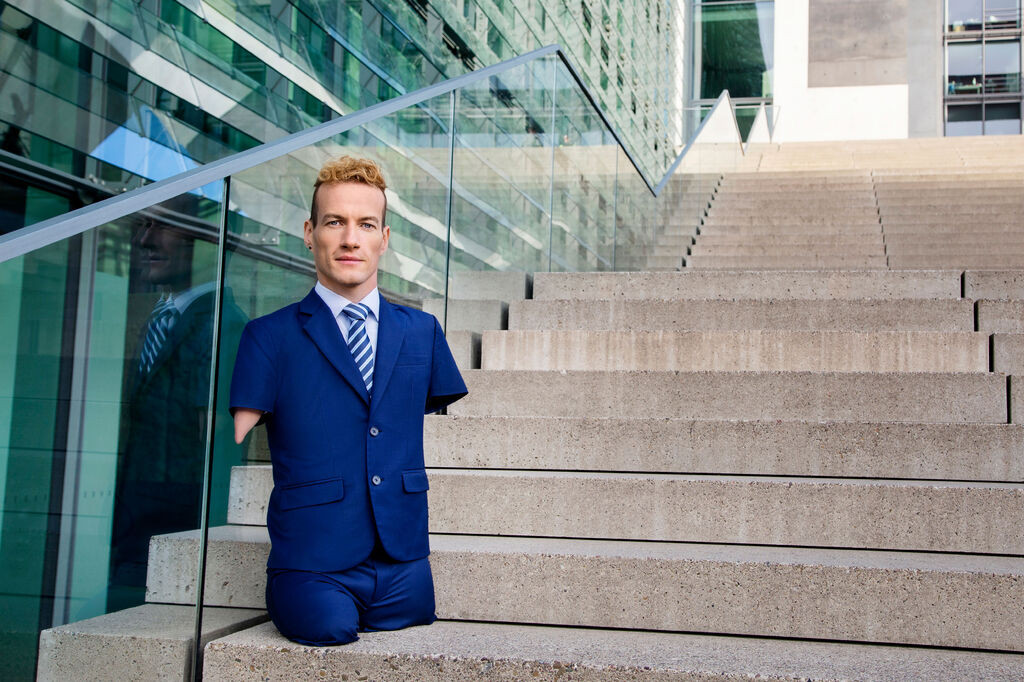 Speaker Janis McDavid auf Stufen im Anzug